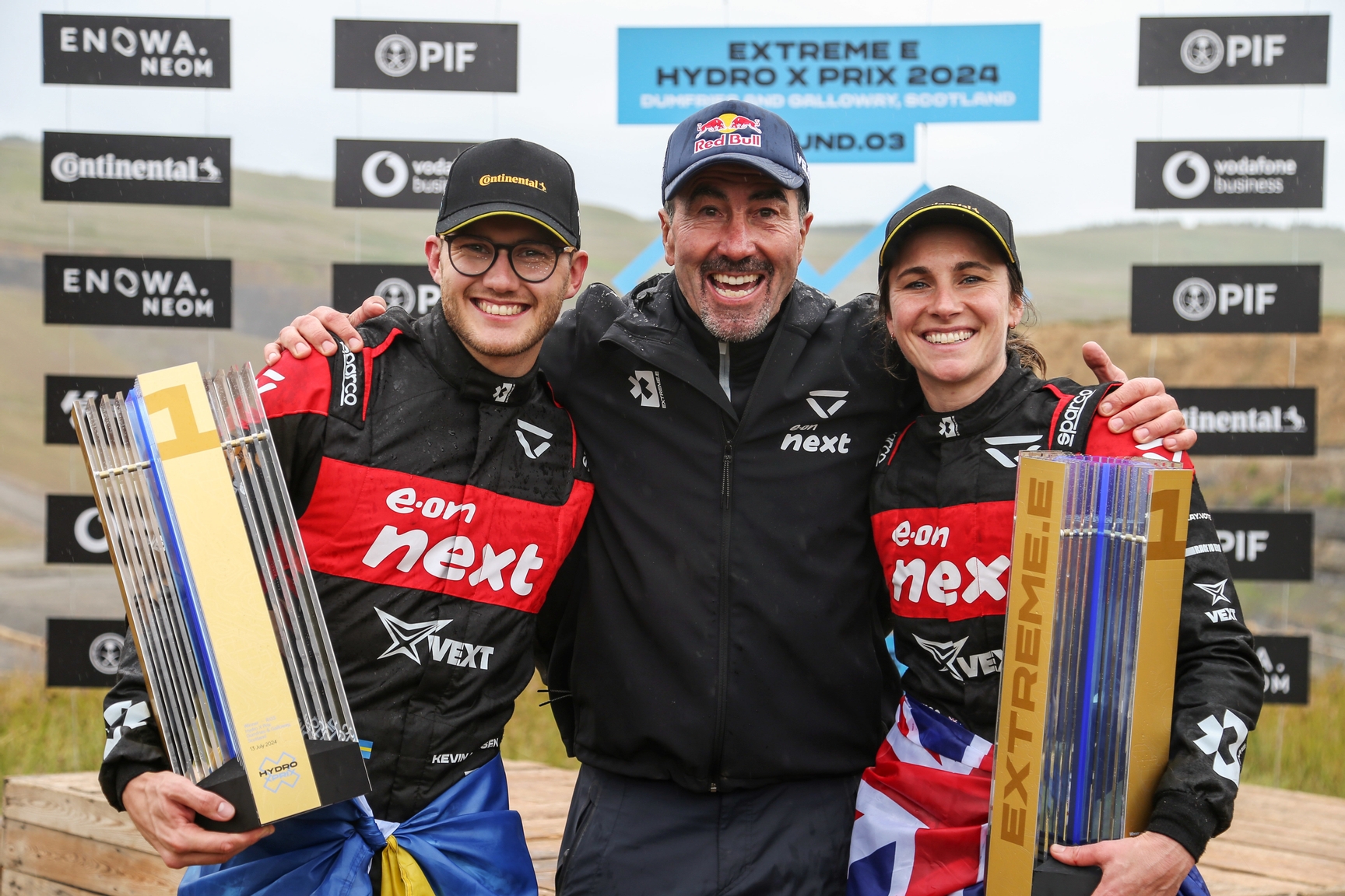 DUMFRIES AND GALLOWAY JULY 13: Kevin Hansen (SWE), Veloce Racing, and Molly Taylor (AUS), Veloce Racing, 1st position, celebrate with Luc Alphand, Team Principal, Veloce Racing, on the podium during the Hydro X-Prix on July 13, 2024 in Dumfries and Galloway. (Photo by Dom Romney / LAT Images)