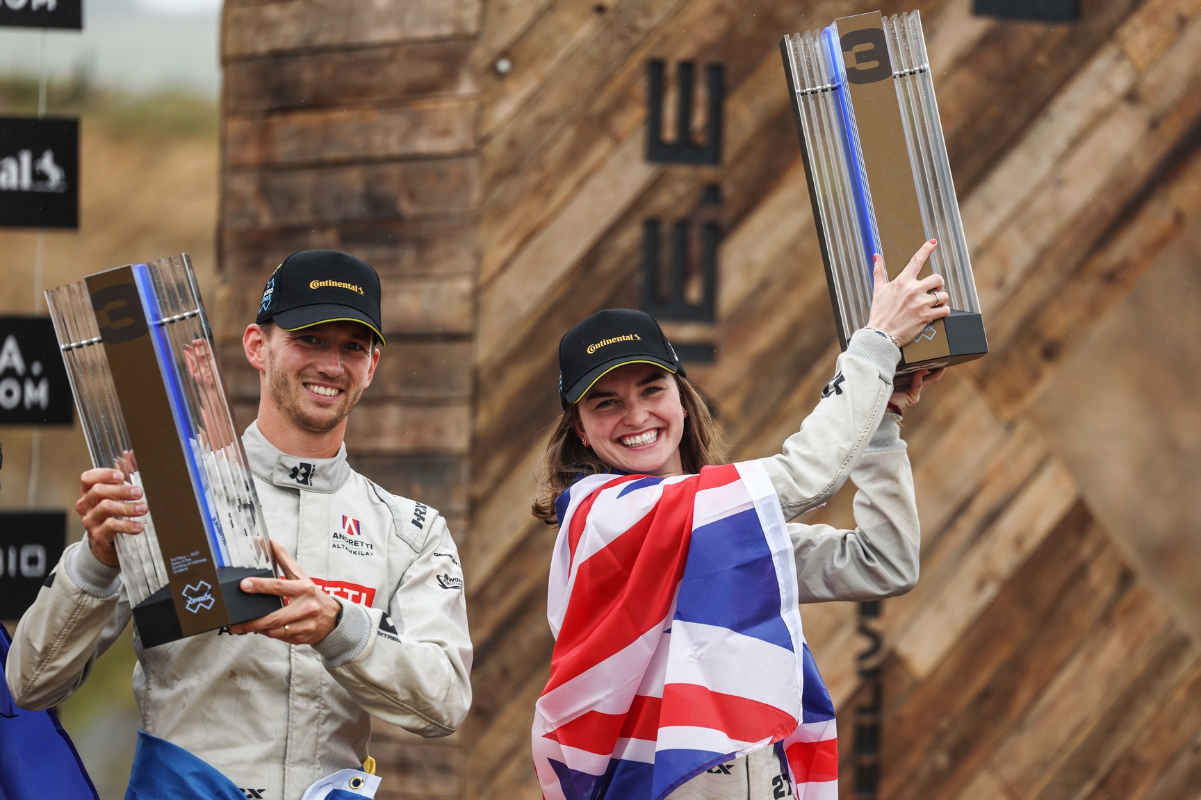 DUMFRIES AND GALLOWAY JULY 13: Timmy Hansen (SWE), Andretti Altawkilat Extreme E, and Catie Munnings (GBR), Andretti Altawkilat Extreme E, 3rd position, with their trophies on the podium during the Hydro X-Prix on July 13, 2024 in Dumfries and Galloway. (Photo by Alastair Staley / LAT Images)